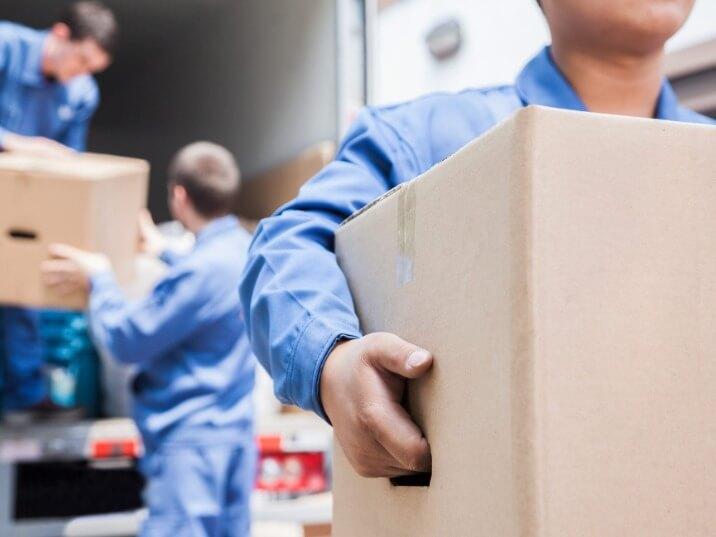 men lifting heavy boxes into a moving van